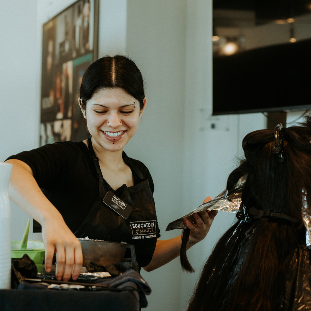 cosmetology-student-dying-hair-square An Educators of Beauty Student Applies Hair Coloring in Her Class